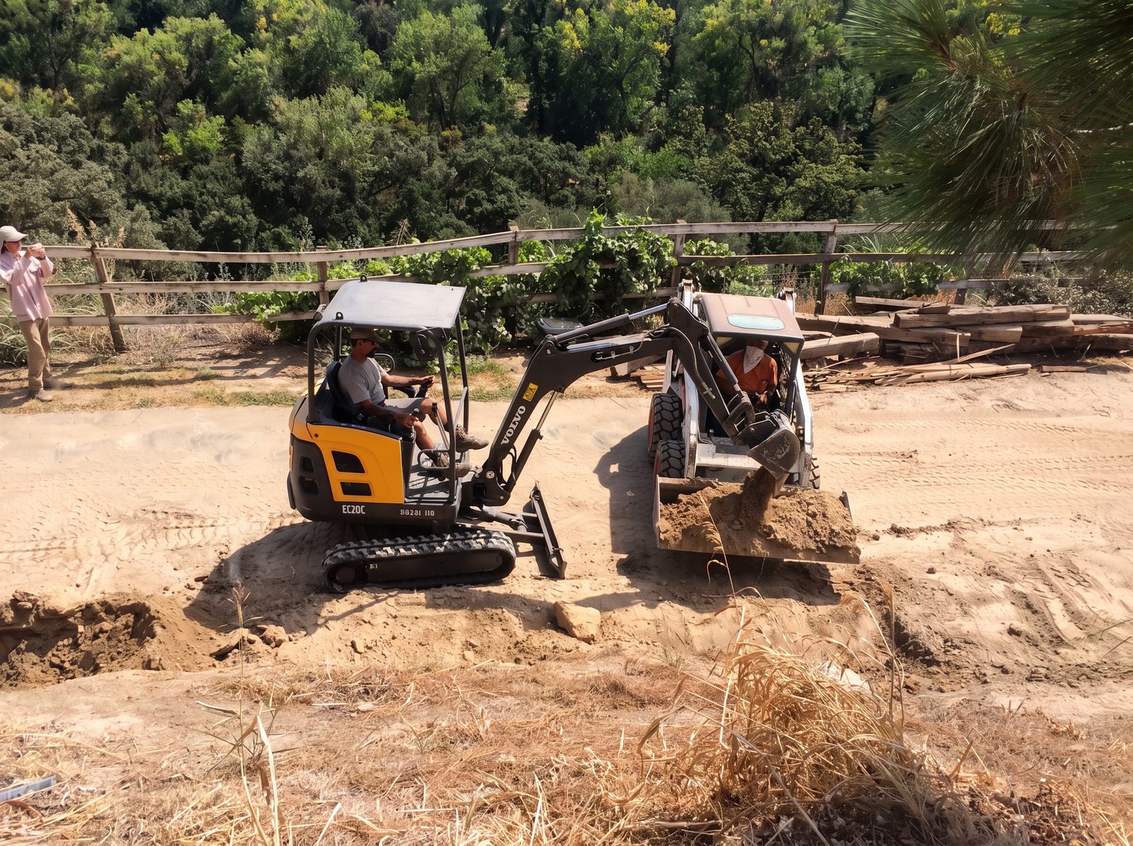 Ultimate Concrete crew preparing a footing trench with a mini excavator and skid steer